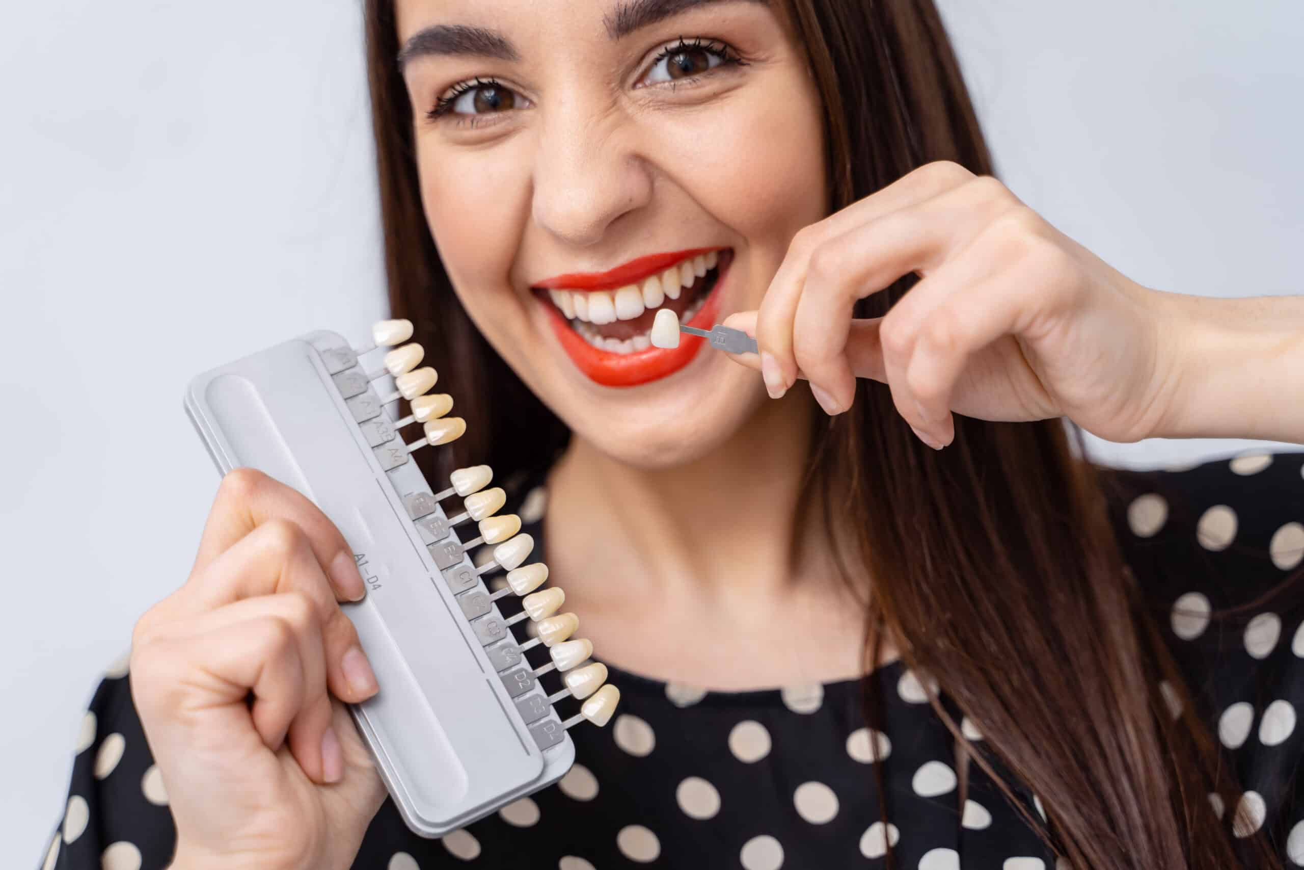 Young woman brushing her teeth with manual toothbrush close-up Choosing Between Crowns and Veneers for the Best Smile