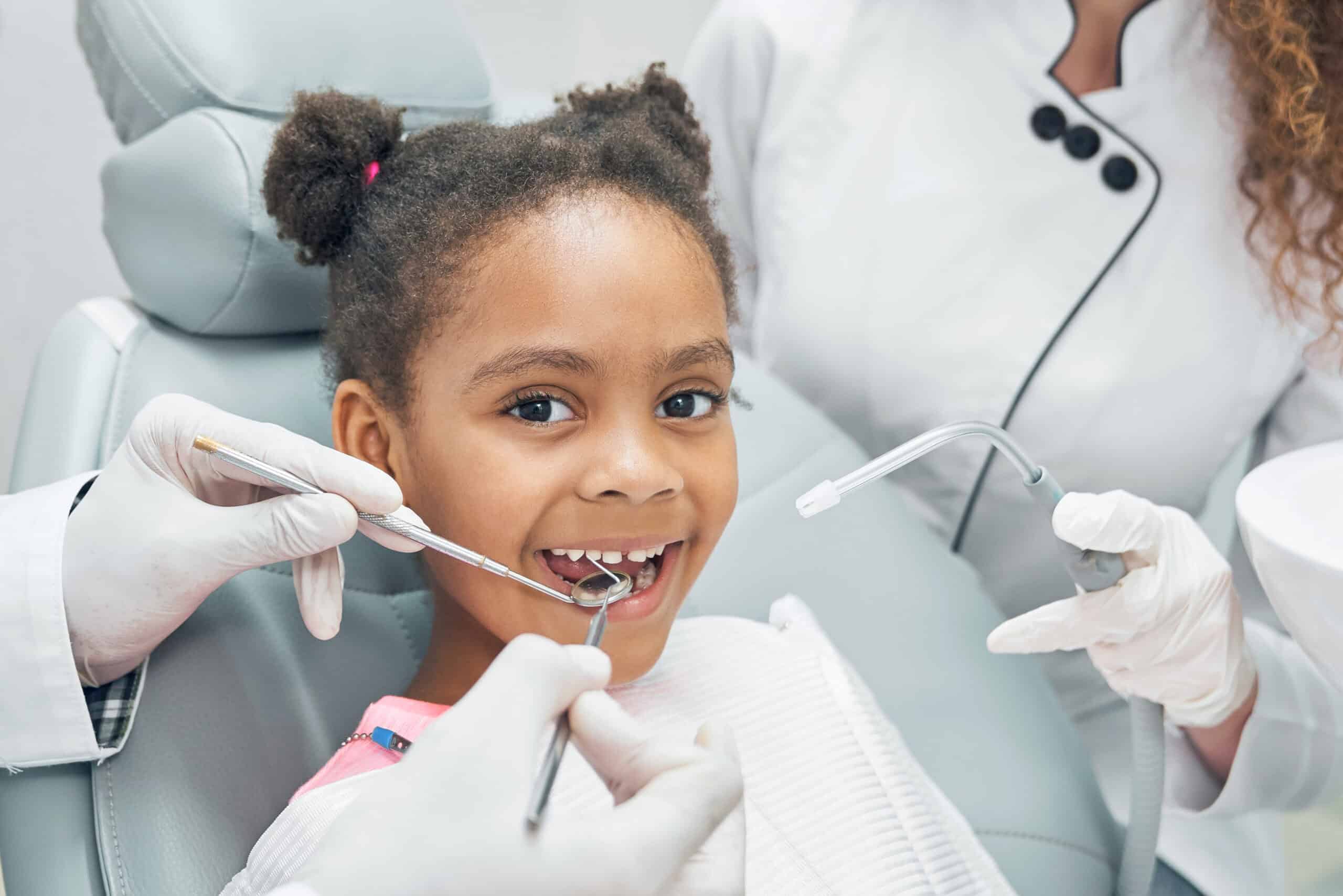 Happy afro kid on regular check up of teeth in dental clinic Choosing the Right Pediatric Dentist for Your Child
